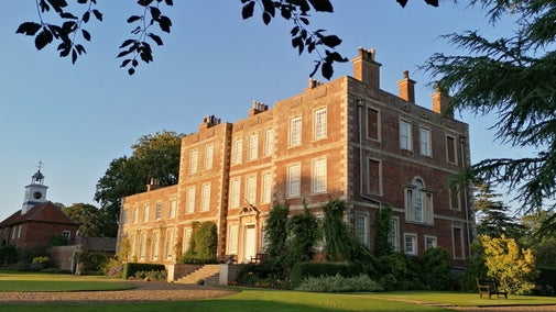 The front of Gunby Hall being brightened by the setting sun.